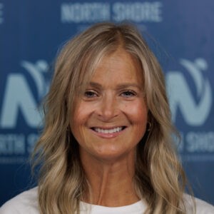 Smiling woman in front of blue background.
